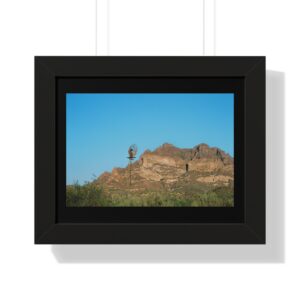 Framed landscape photo with windmill and mountains.
